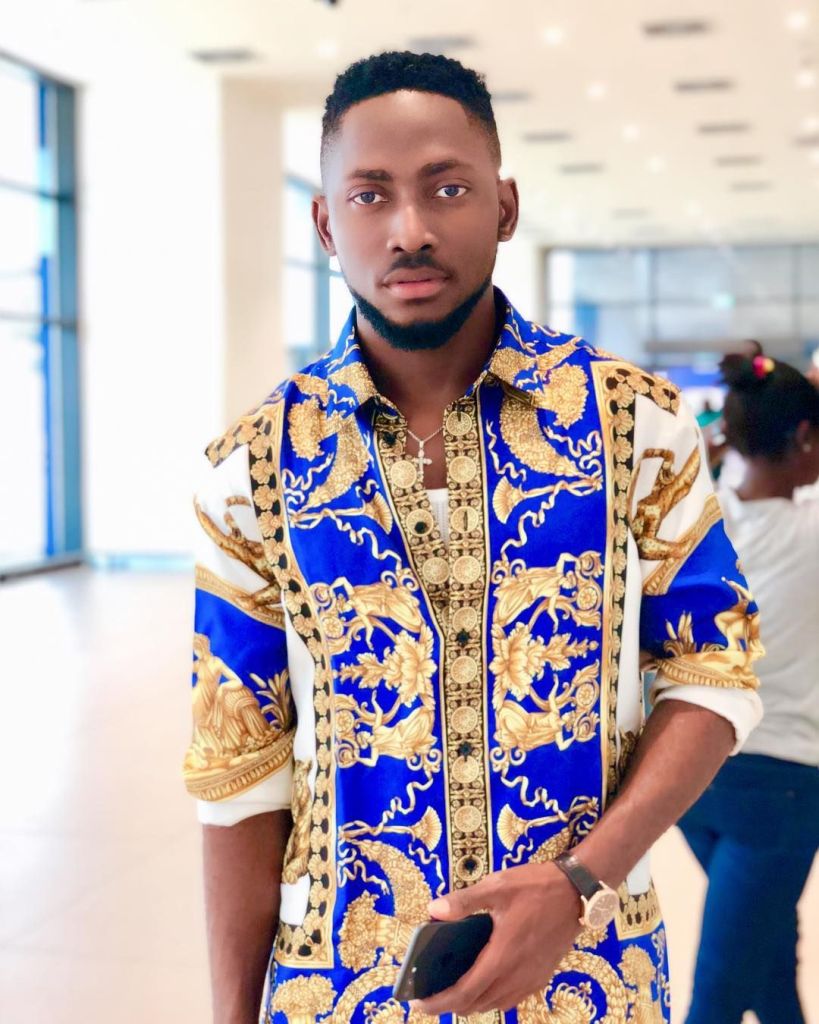 BBNaija star Miracle standing and holding a cellphone