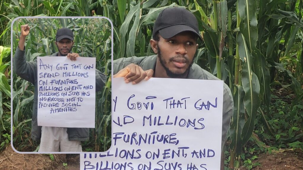 Daniel Regha with a protest placard on his farmland