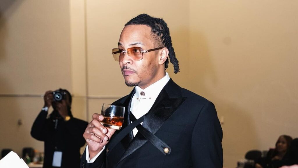 T.I. holding a glass of tequila drink