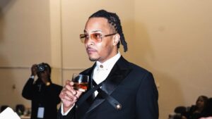 T.I. holding a glass of tequila drink