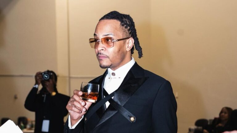 T.I. holding a glass of tequila drink