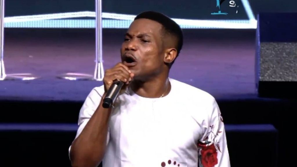 Pastor Jerry Eze holding a mic while preaching to his congregation