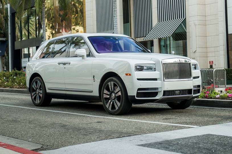 Side view of a Rolls Royce Cullinan, highlighting its profile, wheels, and design details.