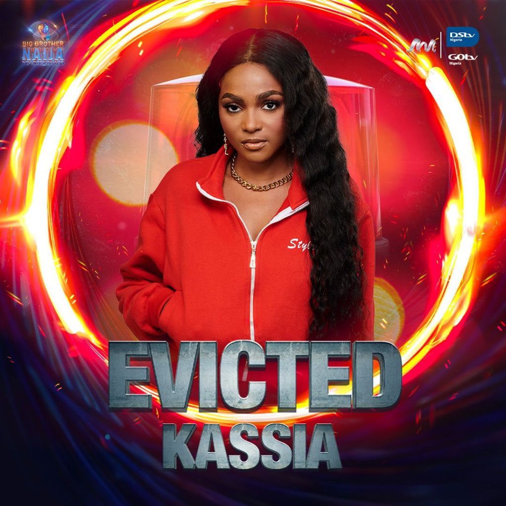 BBNaija star Kassia wearing a red hoodie with the word ‘Styled’ on it. She has long black hair, and the text ‘EVICTED’ is displayed above her name, indicating her eviction from the show. The background features vibrant circular patterns in red and blue hues. Logos of BBNaija, GOtv, and DStv are present in the corners.