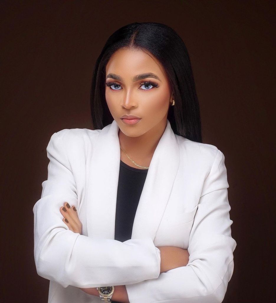 BBNaija star Kassia confidently posing in a white blazer with arms crossed.