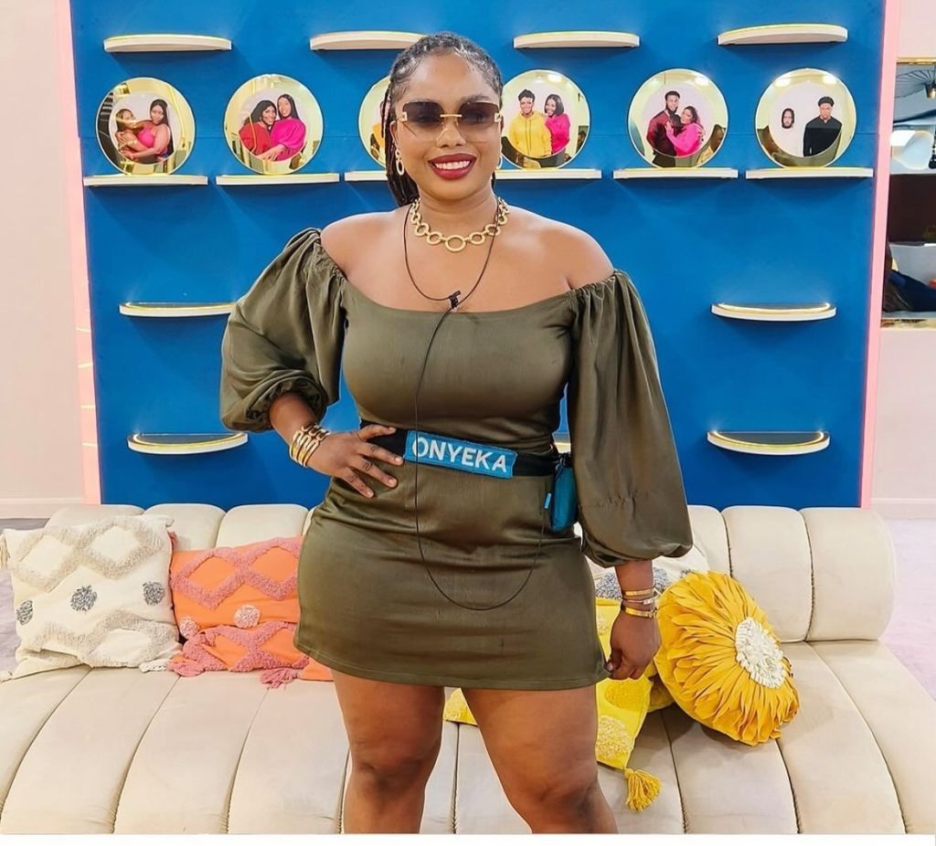 BBNaija star Onyeka posing in a stylish outfit against a textured backdrop, highlighting her unique fashion sense and confidence.