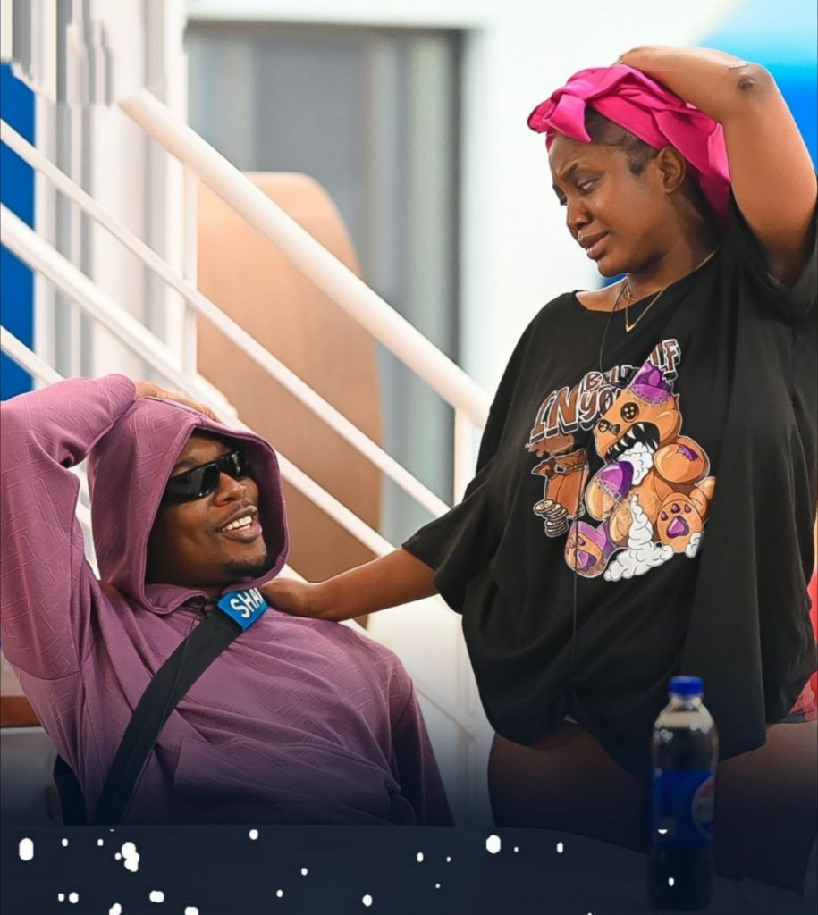 BBNaija stars and lovers Shaun and Wanni on a staircase, with Wanni standing and reaching out to Shaun, who is seated below.