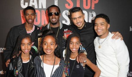 Sean Diddy Combs at an event with six children, standing in front of a backdrop that reads “Can’t Stop Won’t Stop.”