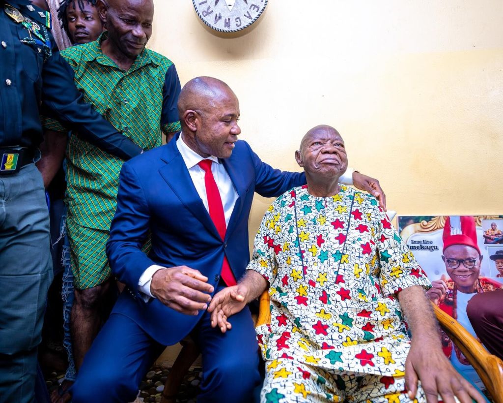 Peter Mbah leaning his left hand on folklore legend Mike Ejeagha during a visit to his residence in Abakpa Enugu.