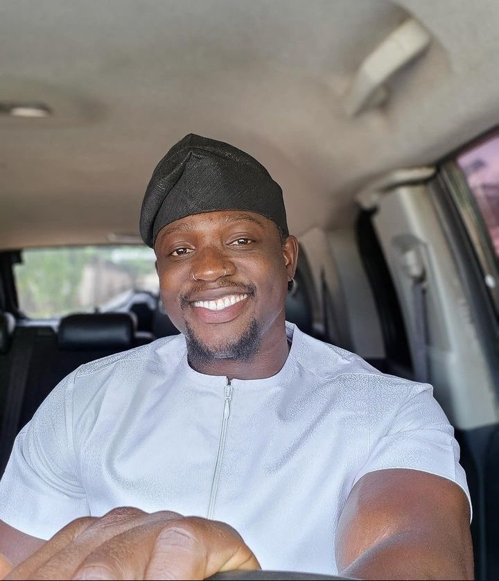 Activist Verydarkman, smiling, dressed in traditional Nigerian attire while seated in a car.