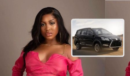 BBNaija star Wanni poses confidently in a stylish pink outfit, with an Innoson IVM Ikenga car prominently displayed alongside her.