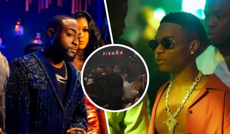 In a lively nightclub atmosphere, two prominent figures Davido and Wizkid are captured in profile. Davido wears a sparkling blue jacket with a gold chain, while Wizkid sports stylish sunglasses and a red shirt adorned with jewelry. The background is filled with colorful lights and a bustling crowd, enhancing the vibrant nightlife vibe.