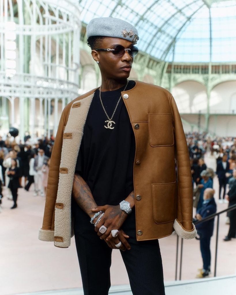 Wizkid wears sunglasses and a stylish beret.