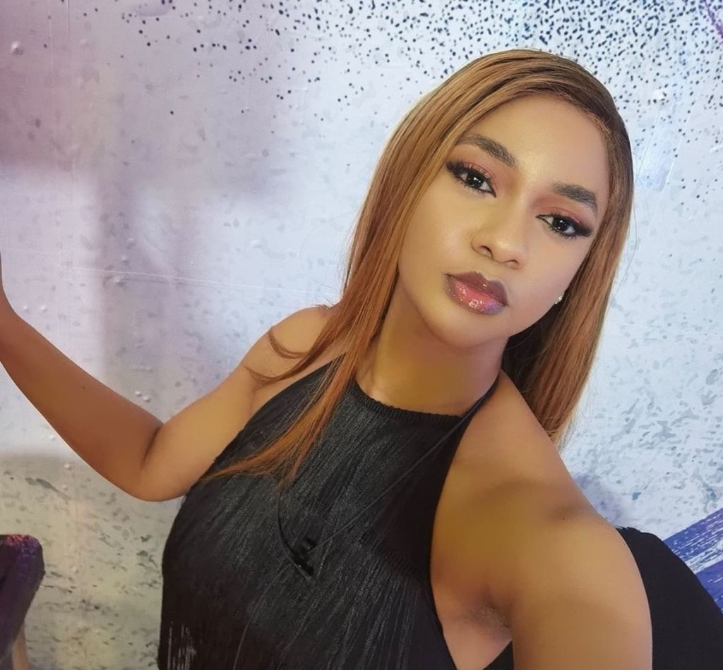 Victoria has long hair and is wearing a black top.