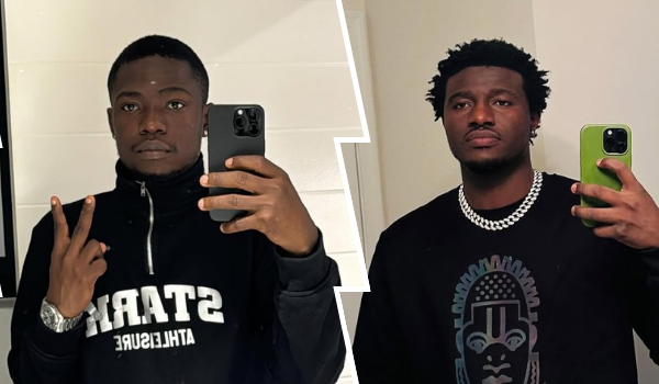 The skit makers Shank Comics and Nasty Blaq are posing for selfies. Shank Comics is wearing a black jacket with white text and making a peace sign with his left hand, while holding a phone in his right. Nasty Blaq is wearing a black shirt with a graphic design and a thick silver chain, holding a green phone in his left hand. Both are standing in front of a white wall.