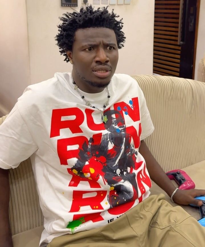 Nigerian comedian Nasty Blaq looking quizzical in a white t-shirt.