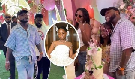 Singer Davido, dressed in a blue checkered shirt and distressed jeans, stands alongside his first baby mama, Sophia, and their daughter, Imade, who is elegantly dressed in white. The festive setting includes colorful balloons, floral decorations, and a tall, decorated cake, highlighting a joyful celebration.