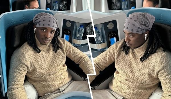 A collage featuring Nigerian skitmaker Lord Lamba, showcasing him seated comfortably in a luxurious airplane seat. He is wearing a patterned beige sweater, a gray bandana with white designs, and wireless earbuds. His long braided hair cascades over his shoulders. The background includes plush blue seats, water bottles, and a small screen, indicating a high-end travel setting. The collage is split vertically, presenting two slightly different angles of the same scene.