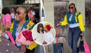 Blessing CEO is seen arriving in Asaba prior to her wedding, wearing a stylish green and yellow jacket with "MEET" on it, holding a bouquet of red roses, and smiling with sunglasses. She is surrounded by people, some offering gifts, while pulling luggage. A smaller inset photo shows her with a her man in a red hat, sharing a tender moment.
