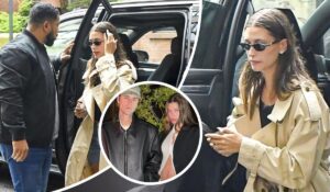 Justin Bieber and Hailey Bieber step out in coordinated style—Hailey in a beige trench coat clutching her phone, and Justin in a sleek black leather jacket, as they casually move through their day.