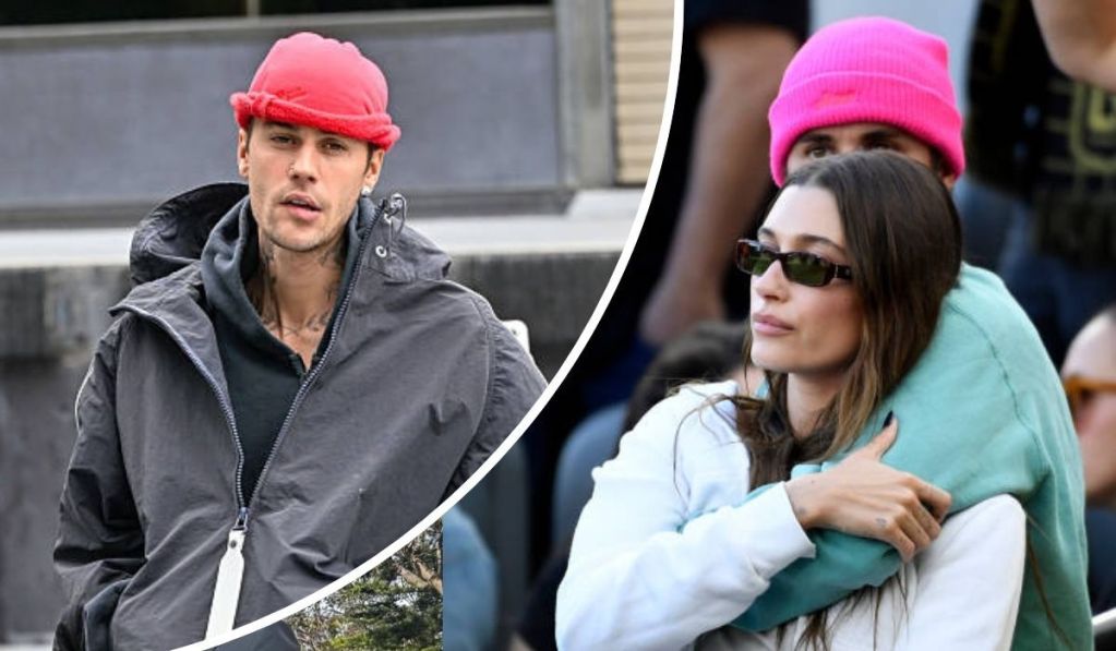 Justin Bieber, dressed in a dark jacket and bright pink beanie, stands beside Hailey, who wears a white top under a green jacket as she embraces him in a casu hial, affectionate moment captured outdoors.