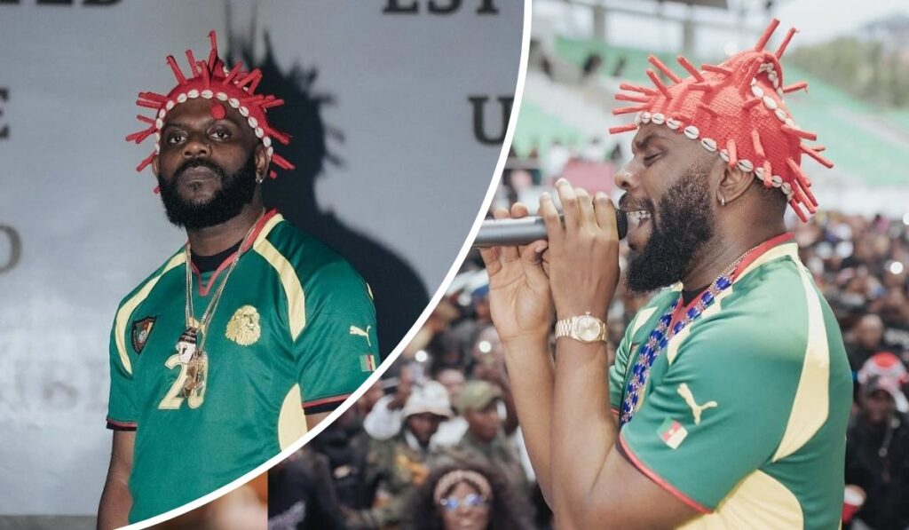 Odumodu Blvck dons a green and yellow Cameroon football jersey with the number 20 and a lion crest, paired with a striking red headwrap decorated with white beads. One panel captures him performing live with a microphone before an energetic stadium crowd.
