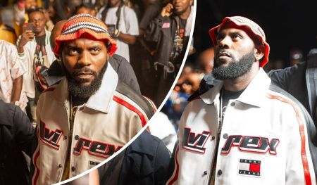 Rapper Odumodublvck stands out in a vibrant crowd, wearing a bold “VIREX” and “TOMMY JEANS” jacket paired with a colorful knit hat, as fans capture the moment around him.