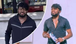 Kayode Peters appears in two distinct settings: on the left, he wears a black jacket with white stripes and a cross necklace, standing beside a bus marked “HOP-ON” and “DA235”; on the right, he holds a patterned bottle while dressed in a dark short-sleeve shirt, accessorized with a cross necklace and bracelet.