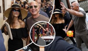 Jeff Bezos and Lauren Sanchez walk hand in hand through a bustling crowd, with Sanchez in a black off-the-shoulder dress and wide-brimmed hat, and Bezos in a casual grey t-shirt. A central inset shows Bezos assisting Sanchez down a step, capturing a candid moment of care amid media attention.