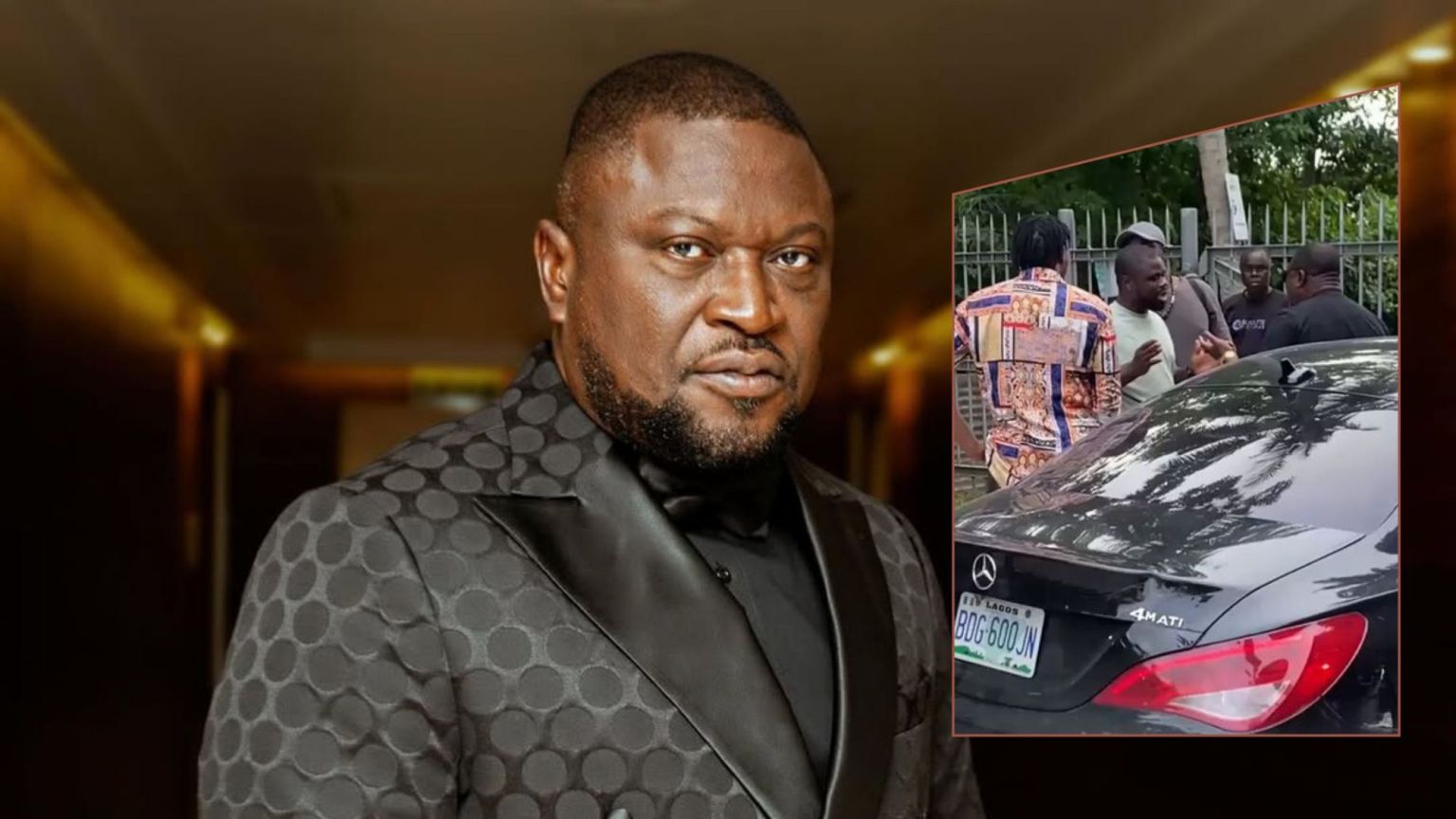 Femi Branch poses in a tailored suit adorned with bold circular patterns, complemented by a satin lapel, black shirt, and bow tie, standing in a warmly lit corridor that exudes elegance.