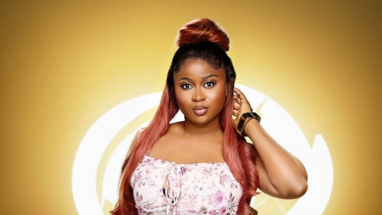 BBNaija Season 10 housemate Imisi posing in a floral outfit with long ombré hair against the signature Big Brother Naija eye logo backdrop.