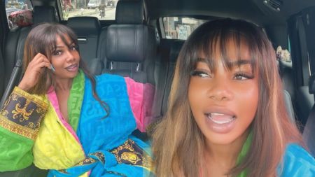 Tacha is seen seated inside a car, wearing a colourful Versace robe, with a confident expression and styled fringe hair.