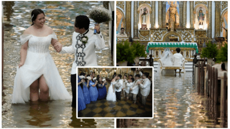 A newlywed couple walks hand in hand through knee-deep floodwaters inside a historic church in the Philippines. The bride smiles in her soaked white dress, while the groom holds her bouquet. Guests dressed in blue and white join the joyful celebration, despite the flooded venue. The altar, richly adorned in gold, stands in the background.