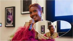 Ayra Starr smiles while holding a microphone during a lively conversation, dressed in a gold vest and pink feathered sleeves, with a heart-shaped inset showing her laughing mid-speech in the same setting.