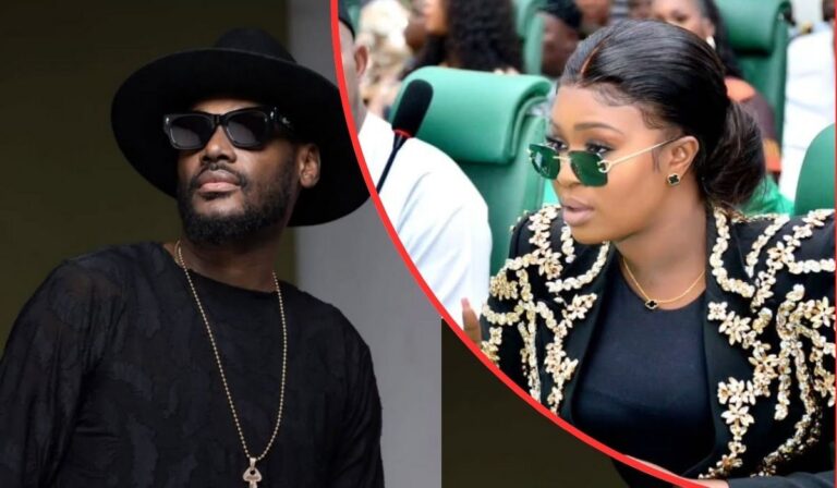 Singer 2baba, dressed in a black outfit with a gold chain and hat, poses beside Natasha Osawuru, who wears a black top with gold embroidery and matching earrings in a formal setting.