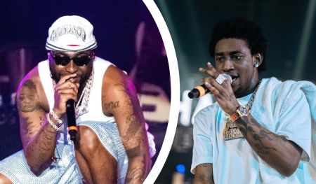 Davido and Shallipopi take the stage in bold style—Davido sports a white sleeveless shirt, a matching cap, and blue shorts, while Shallipopi rocks a light blue shirt with a towel over one shoulder. Both artists hold microphones, flashing their jewelry and tattoos as they perform with high energy and charisma.