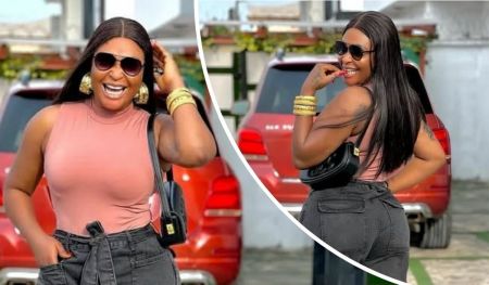 Blessing CEO smiles confidently in stylish casual outfit with dark sunglasses, gold accessories, and black handbag, posing in front of a red SUV; related to her viral “husband snatcher” comments.