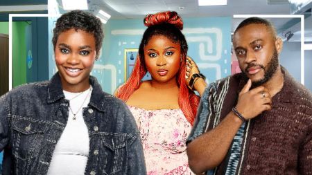 BBNaija Season 10 housemates Dede, Imisi, and Kola pose inside the house. Dede smiles in a black denim jacket over a white top, Imisi stuns in a pink floral dress with her long red hair styled in an updo, while Kola strikes a thoughtful pose in a striped brown shirt.