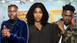 BBNaija Season 10 housemates Faith, Sultana, and Jason Jae pose confidently in the Big Brother house arena, with a stylish backdrop featuring vibrant décor and lighting.