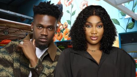 BBNaija Season 10 housemates Jason Jae and Sultana pose confidently in front of a bright floral-themed background inside the Big Brother house.