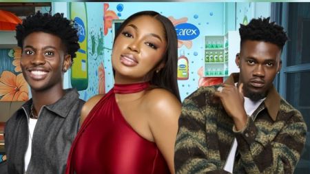 BBNaija Season 10 housemates Koyin, Dede, and Jason Jae posing together inside the Big Brother Naija house, with Koyin smiling in a dark jacket, Dede in a red halter dress, and Jason Jae in a green and brown patterned jacket.