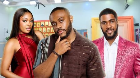 BBNaija Season 10 housemates Mide, Kola and Bright posing inside the Big Brother Naija house. Mide is dressed in a sleeveless red outfit, Kola wears a brown striped shirt, and Bright is in a patterned pink suit jacket over a white shirt.