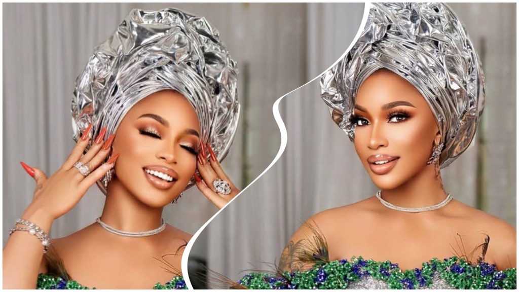 Tonto Dikeh in a shiny silver gele and beaded green-purple dress, soft glam makeup, long nails, and diamond jewellery against a neutral backdrop.