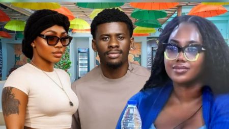 BBNaija Season 10 housemates Sultana, Victory, and Gigi Jasmine posing inside the Big Brother Naija house, with Sultana in a beige crop top and black headwrap, Victory in a light brown top, and Gigi Jasmine in glasses with a blue cardigan.