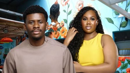 BBNaija Season 10 housemates Victory and Jasmine pose confidently in front of a vibrant floral mural inside the Big Brother house.