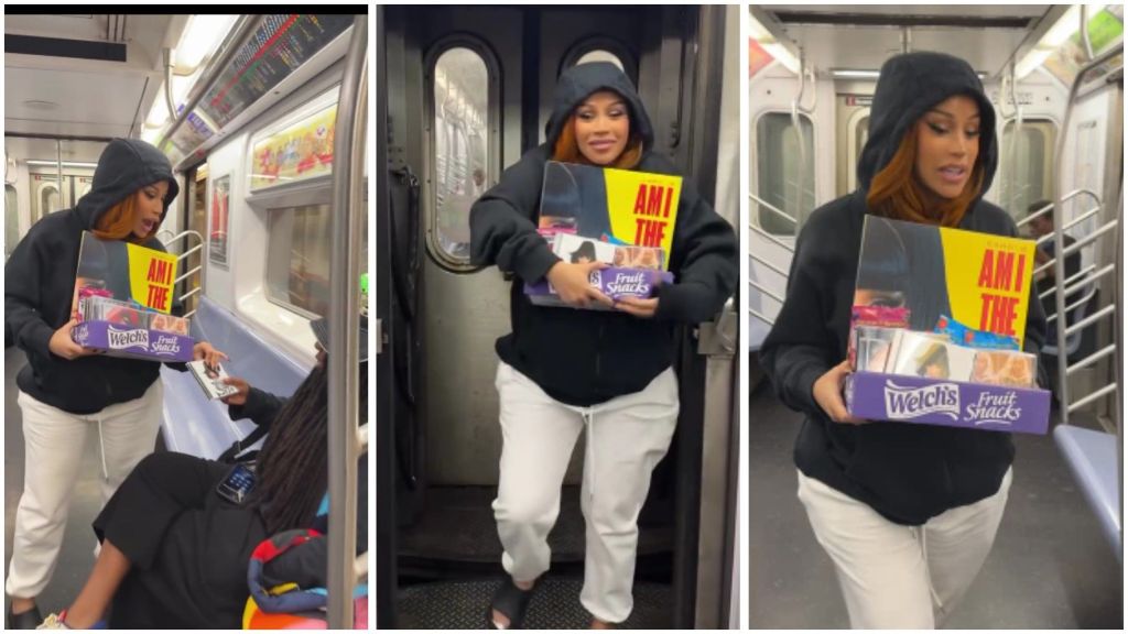 American rapper Cardi B is spotted inside a subway train wearing a black hoodie and white joggers, holding a box of Welch’s fruit snacks filled with CDs of her yet-to-be-released album Am I the Drama. She is seen offering the album to passengers, stepping out of the train with the box in her hands.