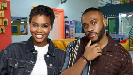 BBNaija Season 10 housemates Dede and Kola posing together inside the Big Brother Naija house, with bright smiles against the colourful lounge background.