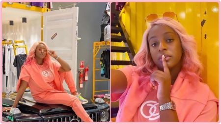 Nigerian DJ and music star DJ Cuppy poses in a bright pink outfit. In the first photo, she sits on the bonnet of a black car wearing matching tracksuit and pink hair. In the second, she takes a close-up selfie with her finger placed on her lips.