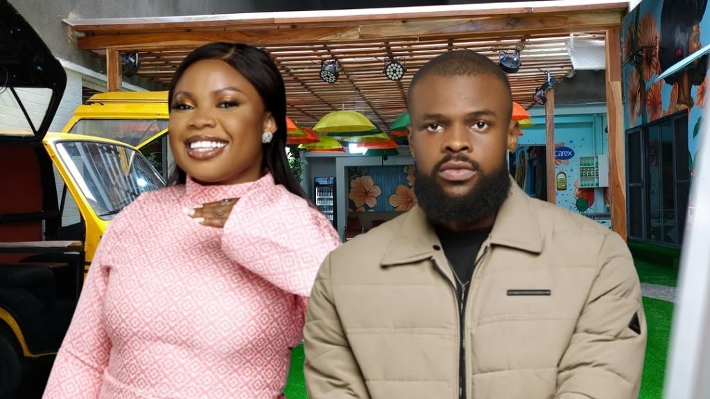 BBNaija Season 10 housemates Doris and Denari pose together in the garden area. Doris beams in a pink patterned dress, while Denari stands calmly beside her in a beige jacket, with the colourful house umbrellas and decor in the background.