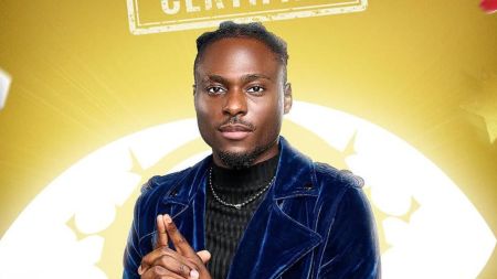 BBNaija Season 10 housemate Dede poses in a denim jacket, smiling in her official portrait against a gold background.